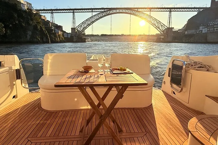Luxury yacht cruising under Porto's Douro bridges with wine on a porto yacht cruise with wine, Portugal