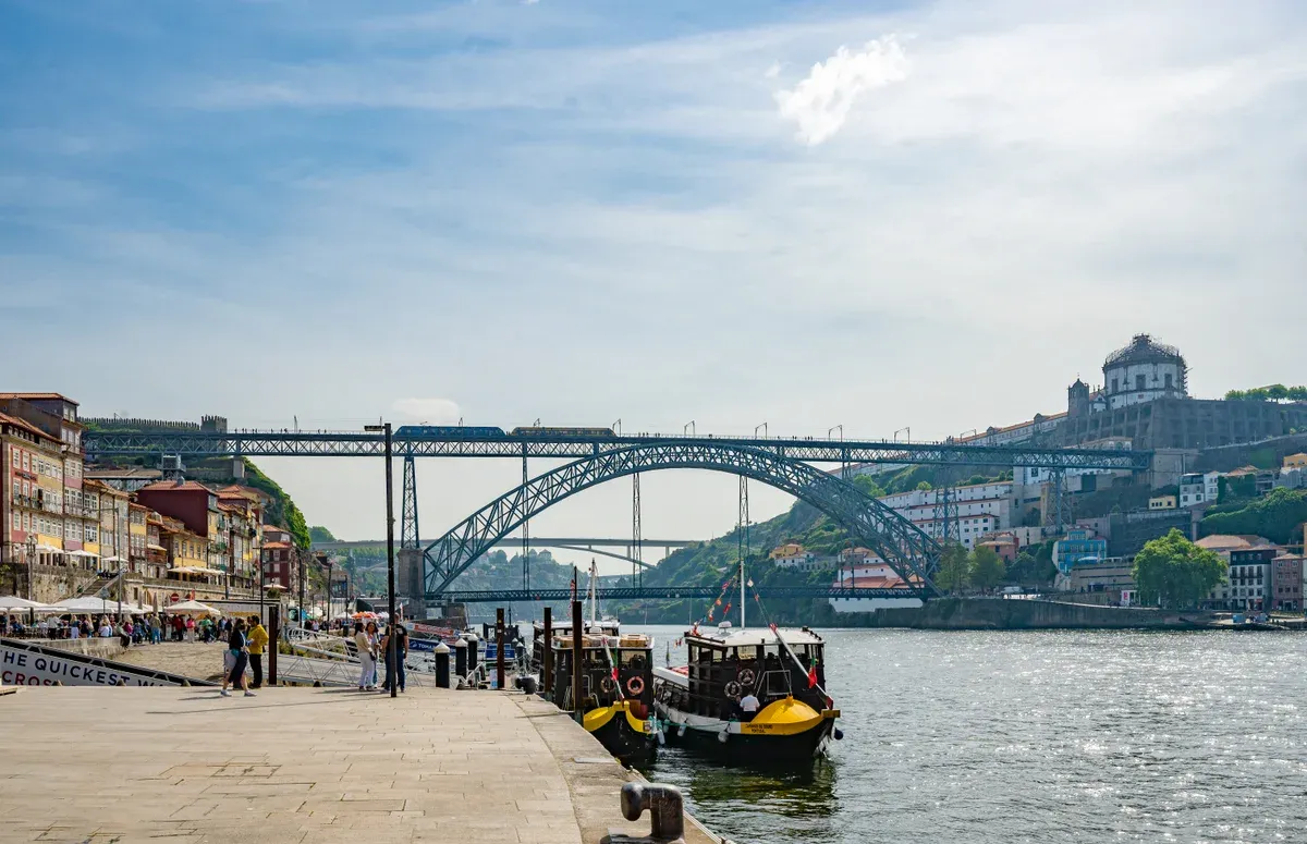 Boats moored below Ponte Luís I at Ribeira on a port wine river cruise in Porto